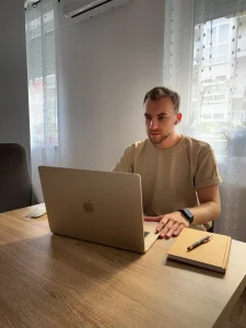 Weboldalkészítő munka közben laptopnál ülve, letisztult irodai környezetben